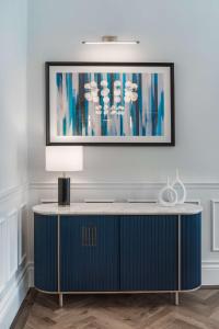 uma sala de estar com um armário azul e um quadro na parede em Mornington Hotel London Kensington, BW Premier Collection em Londres
