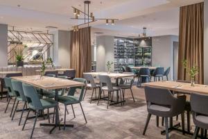 a restaurant with tables and chairs in a room at Radisson Hotel Kaunas in Kaunas