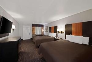 Best Western Executive Inn في غروف سيتي: غرفة فندقية بسريرين وتلفزيون بشاشة مسطحة