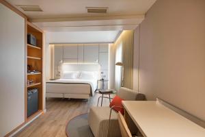 um quarto de hotel com uma cama e uma cadeira em NH Collection Lisboa Liberdade em Lisboa