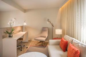 - un salon avec un canapé et un bureau dans l'établissement NH Collection Lisboa Liberdade, à Lisbonne