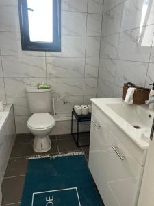 a bathroom with a white toilet and a sink at New apt Stunning view steps from hospital! in Ramat Gan