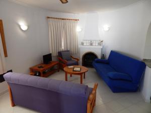 Villa Paloma في Orba: غرفة معيشة مع أريكة زرقاء وطاولة