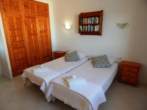 a bedroom with two beds and a book shelf at Villa Paloma in Orba