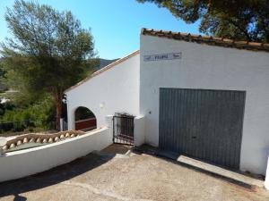 een wit gebouw met een poort en een garage bij Villa Paloma in Orba