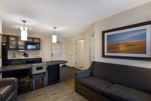 a living room with a couch and a kitchen at Sonesta Simply Suites Des Moines in West Des Moines