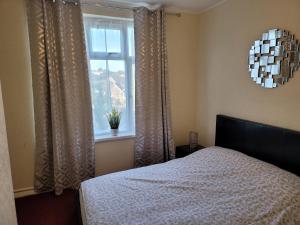 1 dormitorio con cama y ventana en Bright And Homely 1 bedroom flat, en Reading