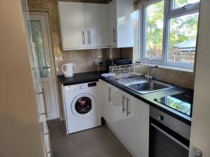 uma cozinha com uma máquina de lavar roupa e um lavatório em Bright And Homely 1 bedroom flat em Reading