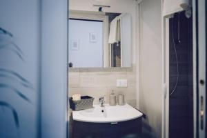 y baño con lavabo blanco y espejo. en Arco delle Monache, en Monterotondo