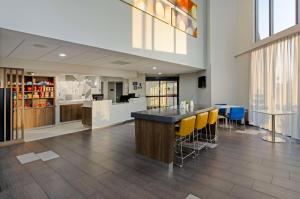 a lobby with a bar with yellow bar stools at Best Western Plus Harrisonburg in Harrisonburg