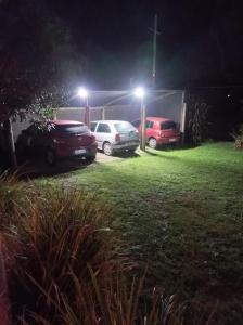 tres autos estacionados en un estacionamiento por la noche en La Residenza, en Santa Ana