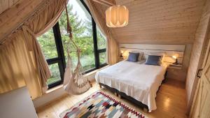 Un dormitorio con una cama en una habitación con ventanas. en Domki Całoroczne nad Morzem Kraina Bałtyku, en Przewłoka 28 fotos más