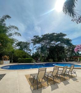 un gruppo di sedie a sdraio accanto alla piscina di Dream Site near Punta Leona a Jacó