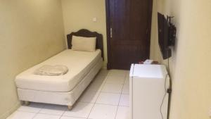 Habitación pequeña con cama y nevera. en سلسبيل للغرف المفروشة en Al Khobar