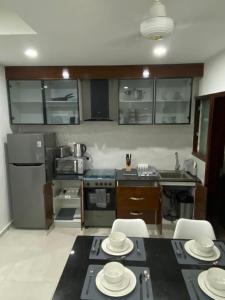 uma cozinha com uma mesa com placas brancas em Benteh Aqua View em Banjul