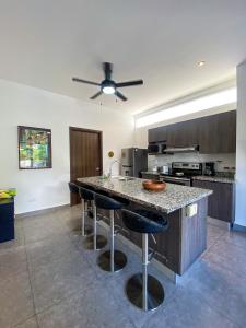 a kitchen with a counter with bar stools at Brand new apartment, minutes from the beach in Jacó