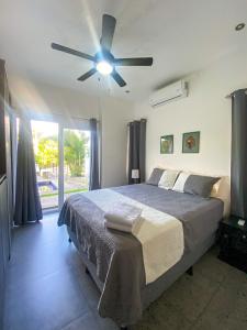 a bedroom with a bed and a ceiling fan at Brand new apartment, minutes from the beach in Jacó