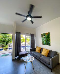 a living room with a couch and a ceiling fan at Brand new apartment, minutes from the beach in Jacó