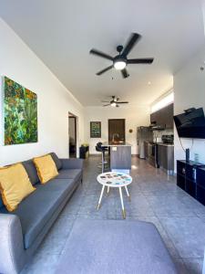 a living room with a couch and a ceiling fan at Brand new apartment, minutes from the beach in Jacó
