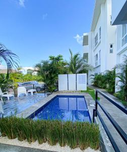 a swimming pool in front of a building at Brand new apartment, minutes from the beach in Jacó