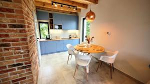 Una cocina y un comedor con mesa y sillas. en Domki Całoroczne nad Morzem Kraina Bałtyku, en Przewłoka