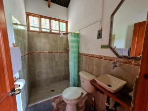 a bathroom with a toilet and a shower and a sink at Casa de campo amplia y tranquila in Juayúa