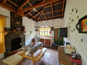 a living room with a table and a fireplace at Casa de campo amplia y tranquila in Juayúa