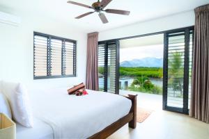 a bedroom with a bed and a large window at Naisoso Island Villas - Fiji in Nadi