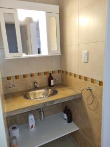 een badkamer met een wastafel en een spiegel bij Departamento Las Calandrias in Cipolletti