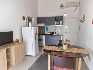a kitchen with a table and a white refrigerator at Departamento Las Calandrias in Cipolletti