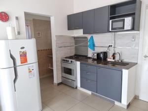een keuken met een koelkast en een fornuis bovenste oven bij Departamento Las Calandrias in Cipolletti +3 foto's