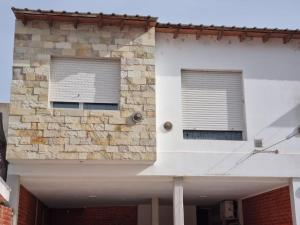 een gebouw met twee ramen met jaloezieën bij Departamento Las Calandrias in Cipolletti