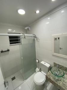 y baño con aseo y ducha acristalada. en Recanto aconchegante no Campeche Apart 03 - 50m da praia -, en Florianópolis
