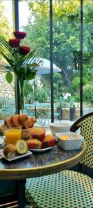 - une table avec un petit-déjeuner composé de fruits et de jus de fruits dans l'établissement Les Glycines de Monchy- Chambres d'hôtes, à Monchy-Humières