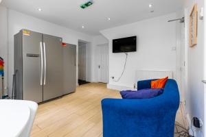 a living room with a blue couch and a refrigerator at Tranquil Six Bedroom Haven in Northampton