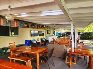 restauracja z drewnianymi stołami i krzesłami w obiekcie Arnott's Lodge & Hiking Adventures w mieście Hilo