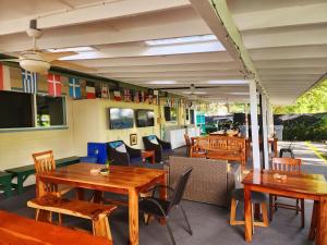 un restaurant avec des tables et des chaises en bois dans l'établissement Arnott's Lodge & Hiking Adventures, à Hilo