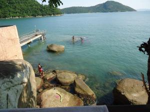 un grupo de personas en el agua cerca de un muelle en Casa a beira mar em Junqueira - Mangaratiba RJ, en Río de Janeiro