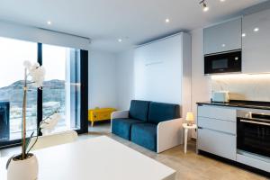 een woonkamer met een blauwe bank en een keuken bij E1 Rock View Studio10 -Hosted by Sweetstay in Gibraltar