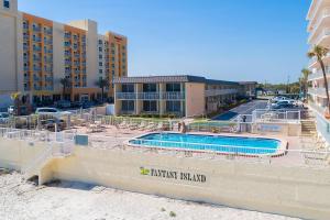 a resort with a swimming pool in front of a building at Fantasy Island Resort I in Daytona Beach Shores