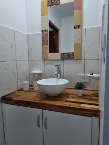 uma casa de banho com um lavatório branco num balcão de madeira em Los Reales em Esquel