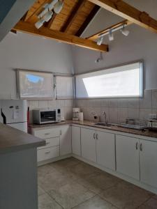 a kitchen with white cabinets and a sink and a window at Los Reales in Esquel