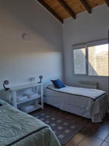 um quarto com 2 camas e uma janela em Los Reales em Esquel
