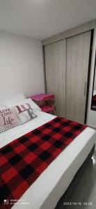 貝約的住宿－Hermoso apartamento en sector exclusivo.，床上有黑色和红色的铺垫毯子