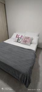 um quarto com uma cama com almofadas em Hermoso apartamento en sector exclusivo. em Bello