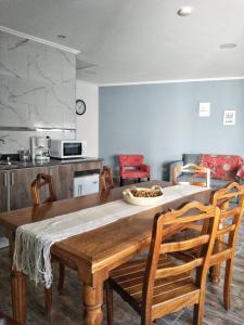 a kitchen with a wooden table and chairs at La Colmena Aparts in El Calafate