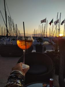 a person holding a glass of wine in front of a marina at Mar-Vada Apartment Relax at the Tuscany coast in Vada