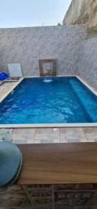 ボイトゥヴァにあるCasa com piscina em boituvaの青い大型スイミングプール(テーブル、椅子付)