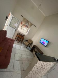 a living room with a couch and a flat screen tv at Casa com piscina em boituva in Boituva