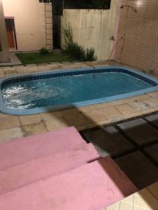 a small swimming pool in a yard with pink tiles at Kitnet- Edícula em Fazendinha in Macapá